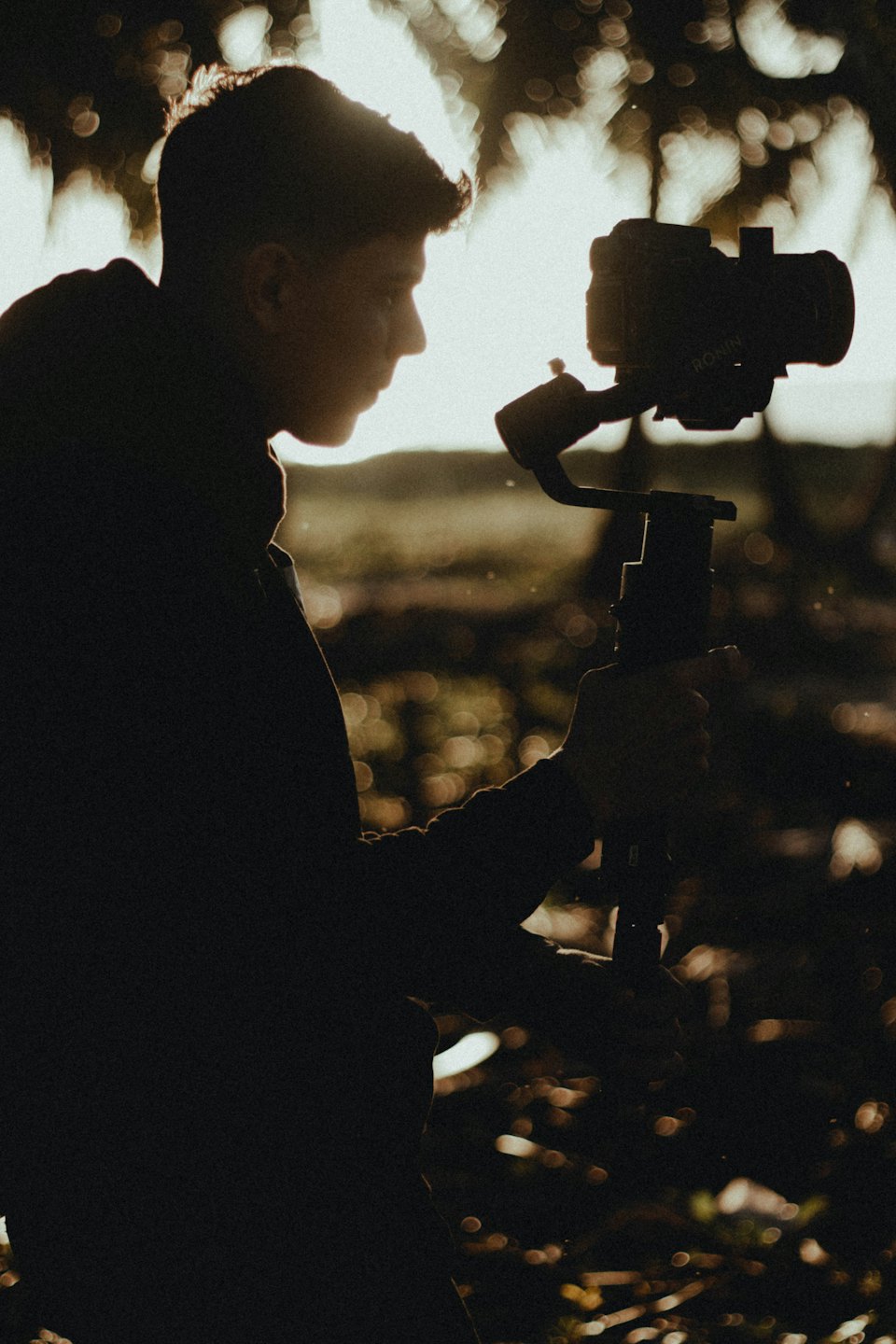 Videograf drží kameru na gimbali v exteriéri.